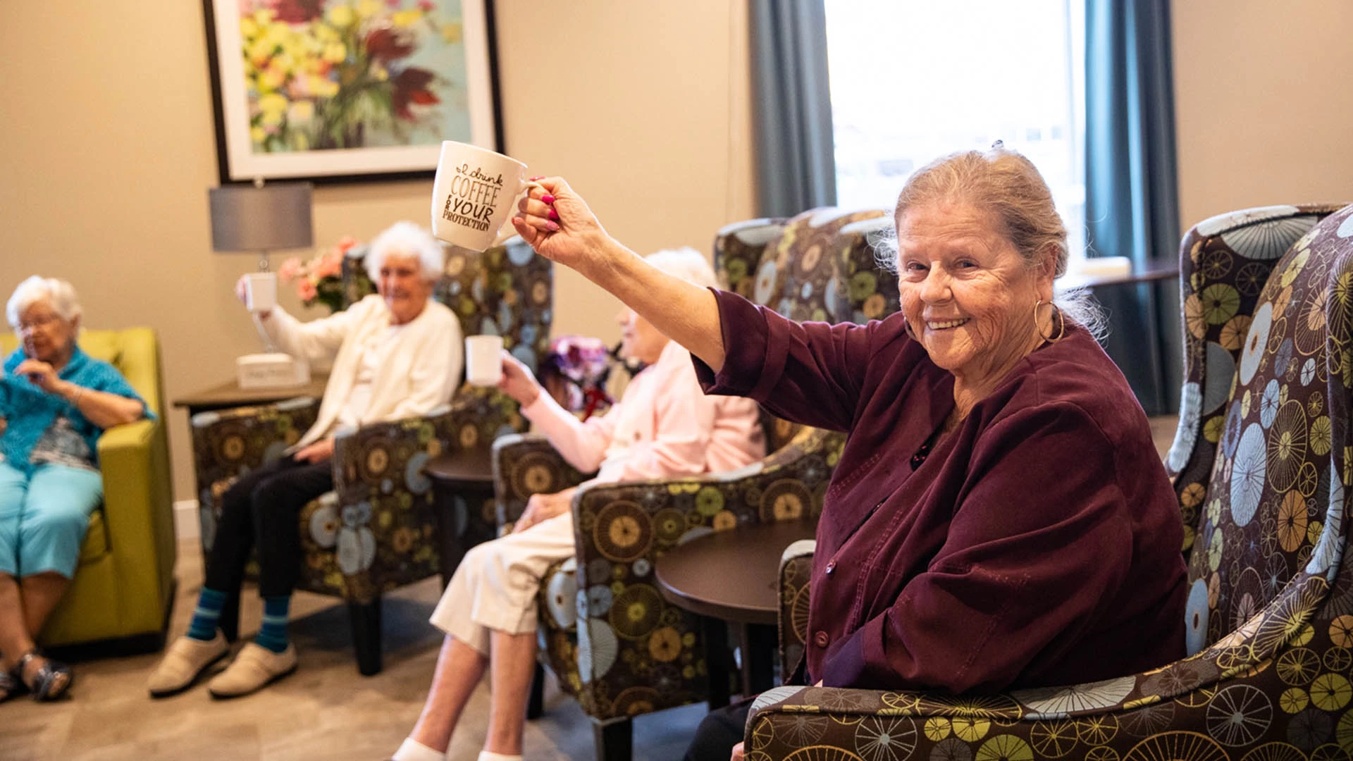 A gathering of senior women cheering with coffee at Vernon's site