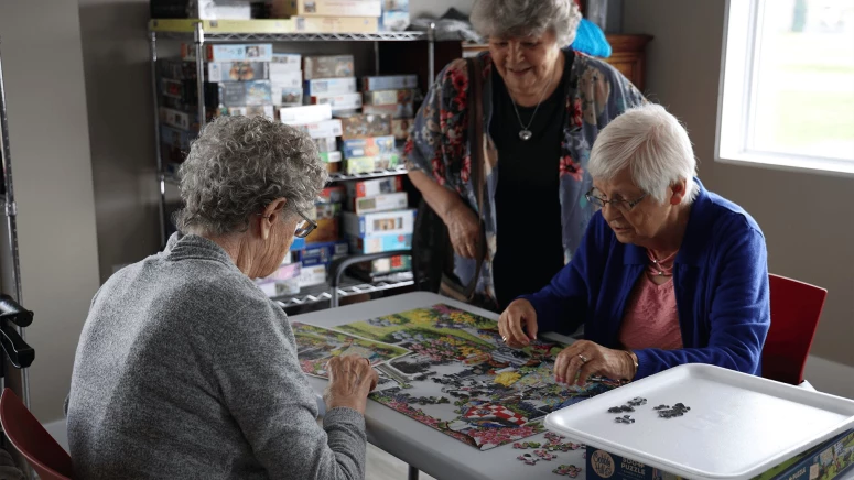 Three elderly women solving Jigsaw puzzle at Vernon's residence